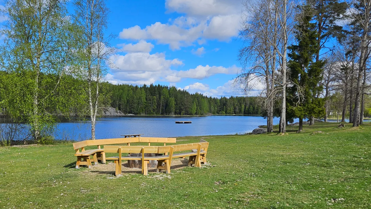 Et piknikbord i tre på toppen av en frodig, grønn åker.