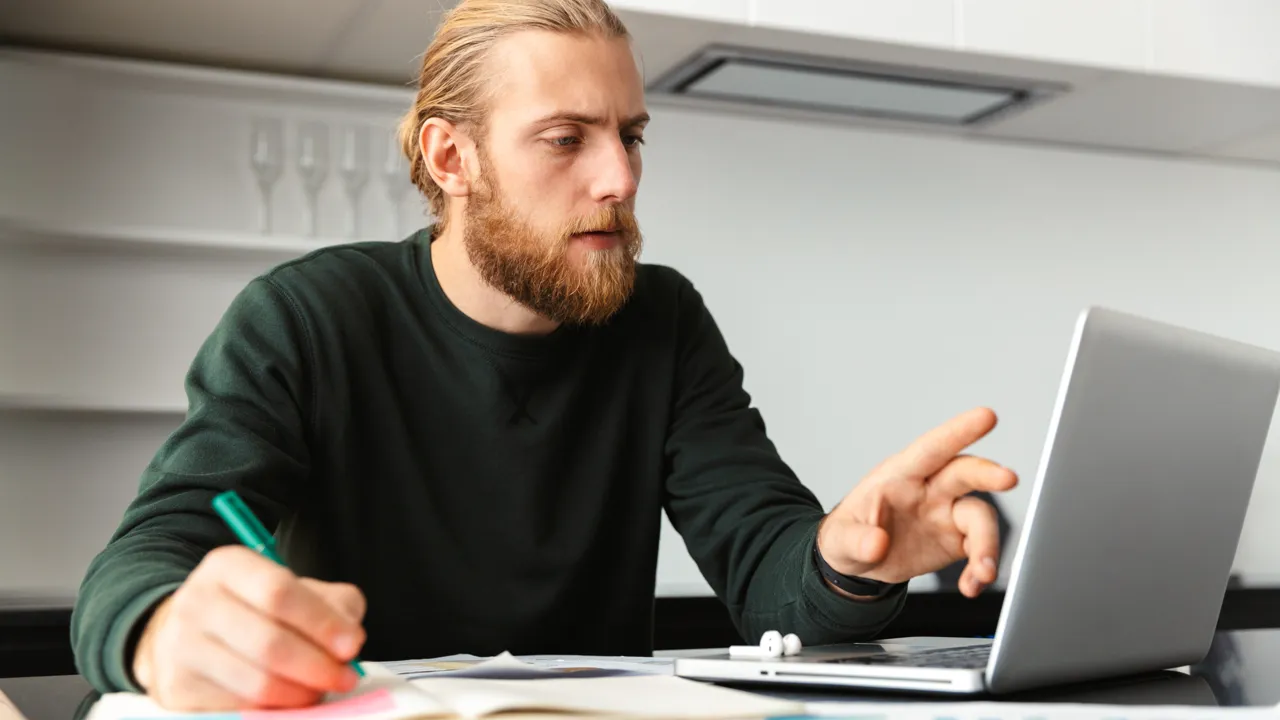 Mann ser på dataskjerm.