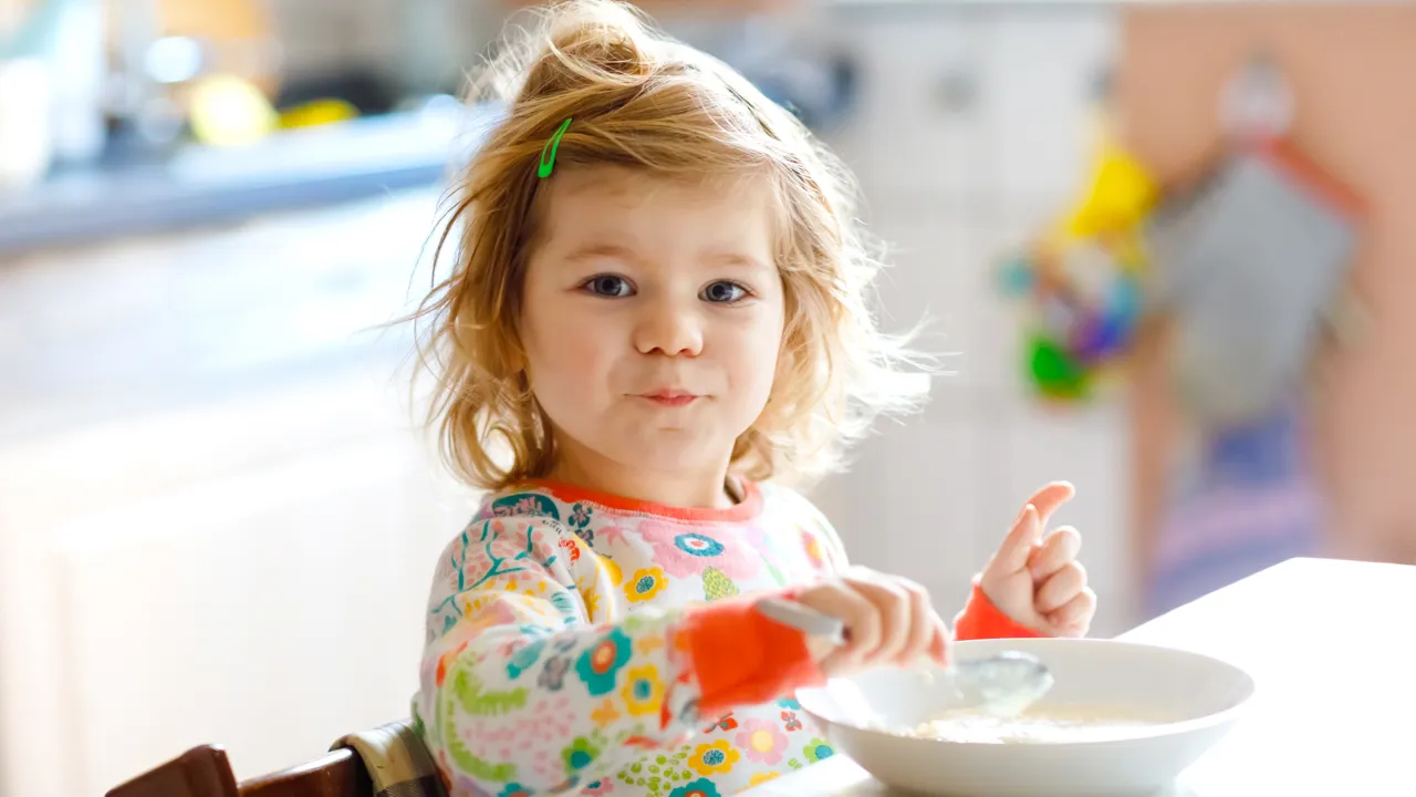 Søt jente spiser grøt.
