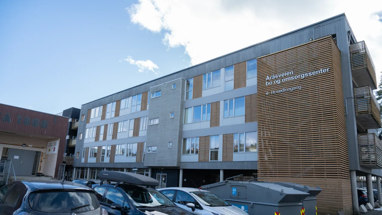 En gruppe biler parkert foran en bygning.