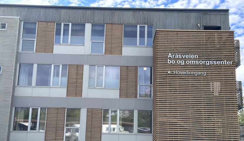 En bygning med fire etasjer og mange vinduer.