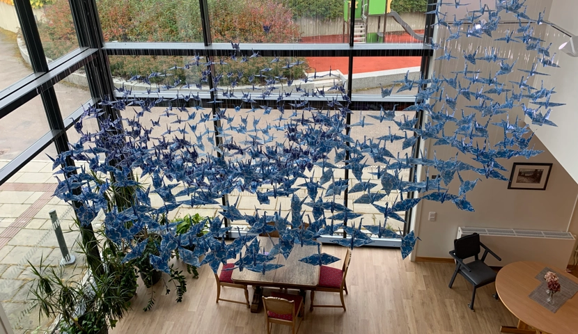 Et rom fylt med massevis av blå sommerfugler som henger fra taket.