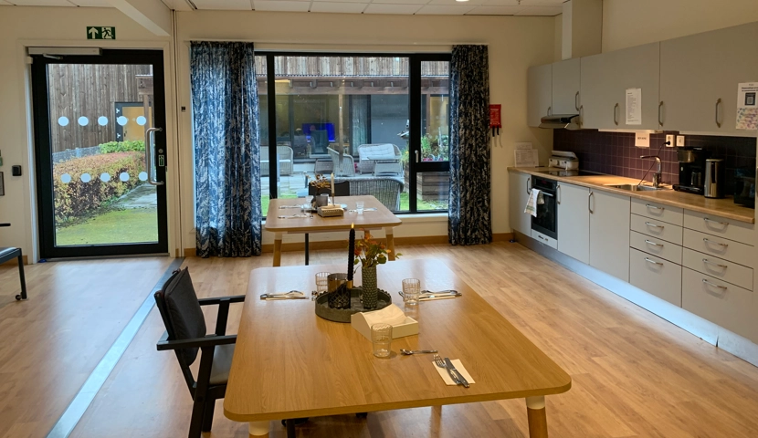 Et kjøkken med bord og stoler.