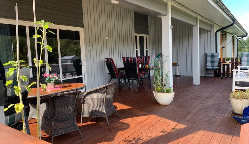 Et tredekke med stoler og bord.