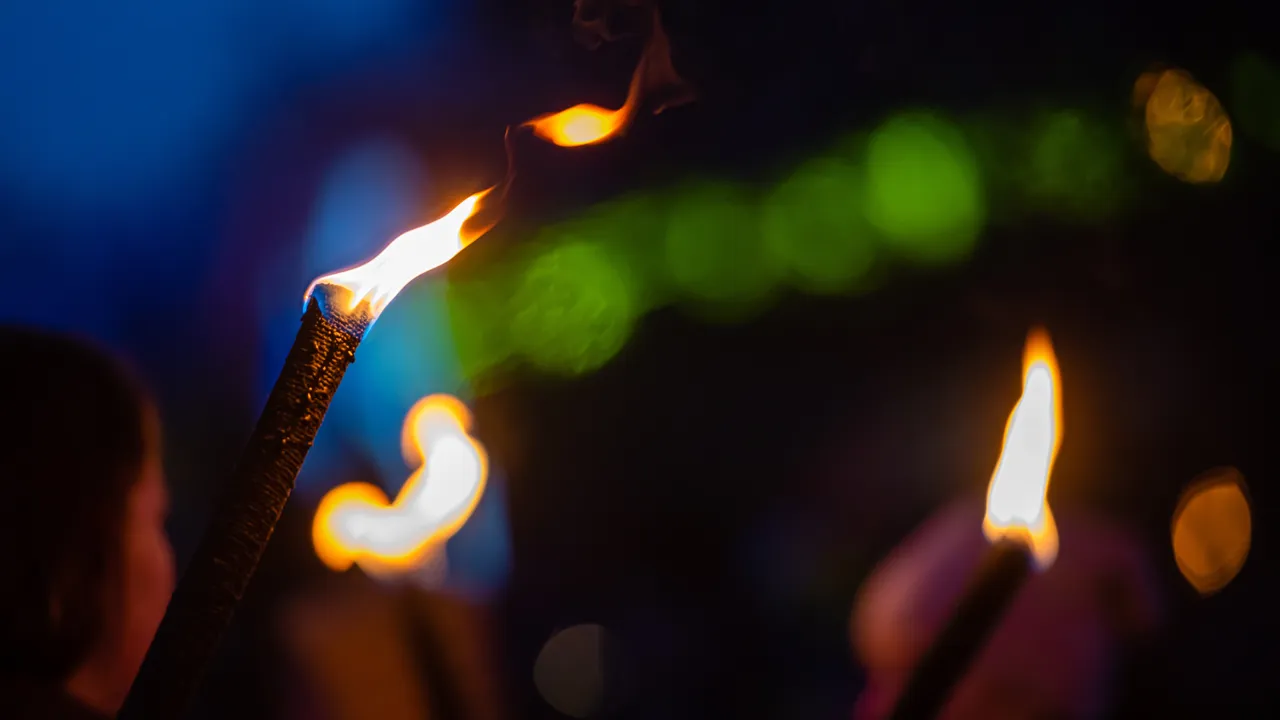 Uskarpe flammer fra fakler ute på kvelden