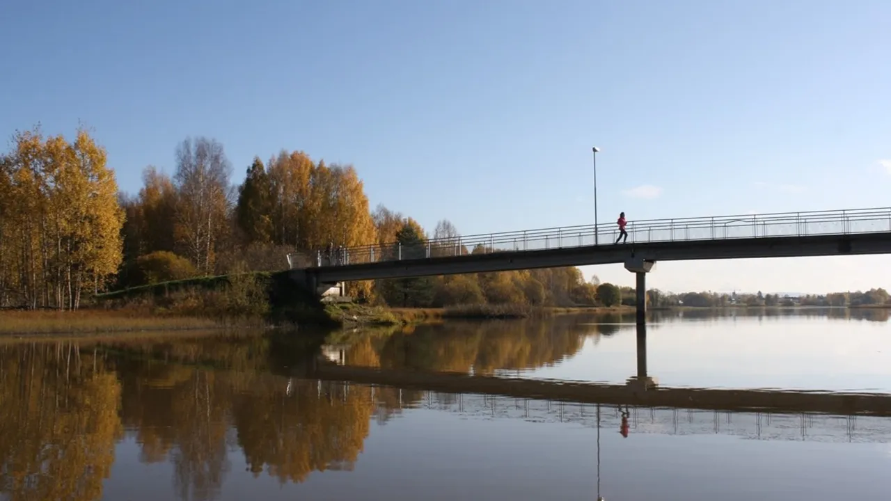 En person som går over en bro over en elv.