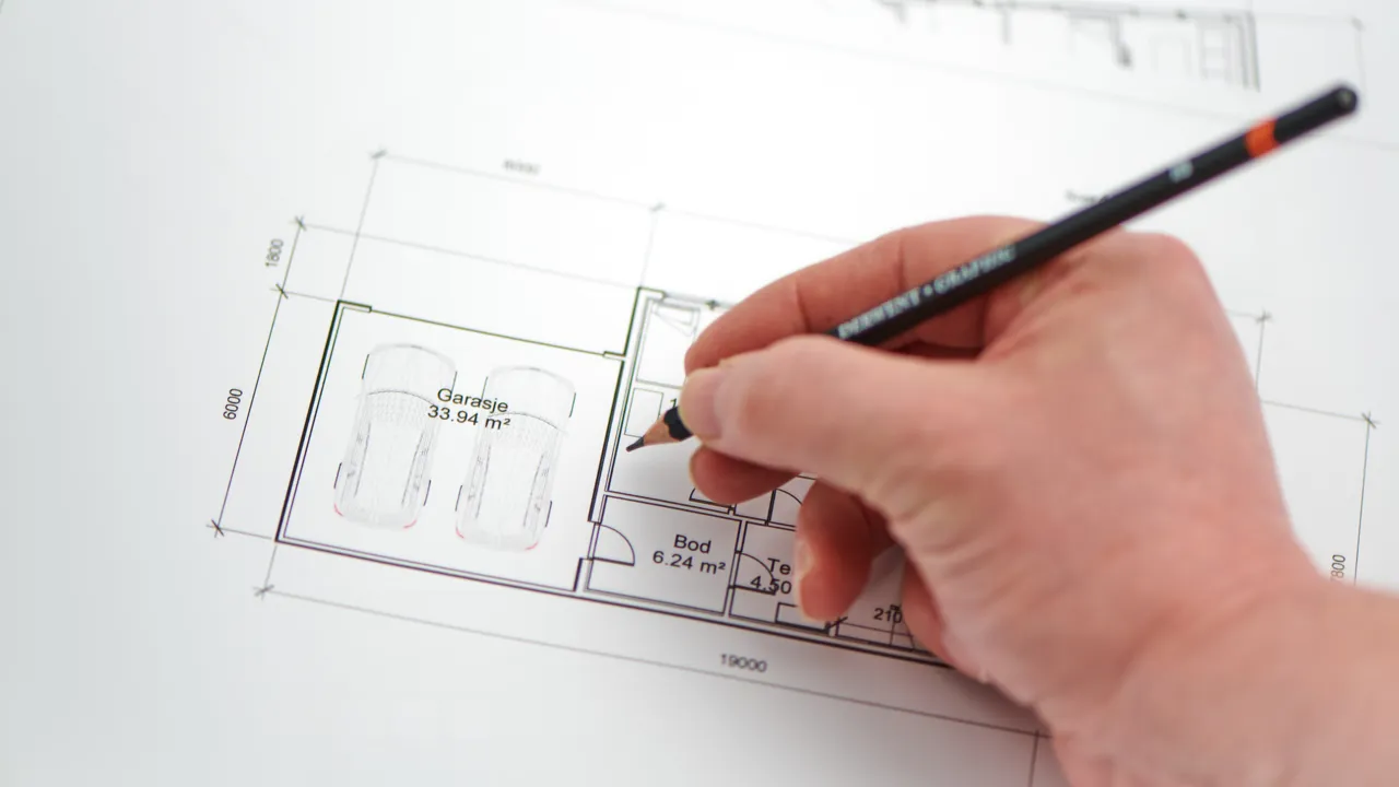 Person skriver på et ark med en penn