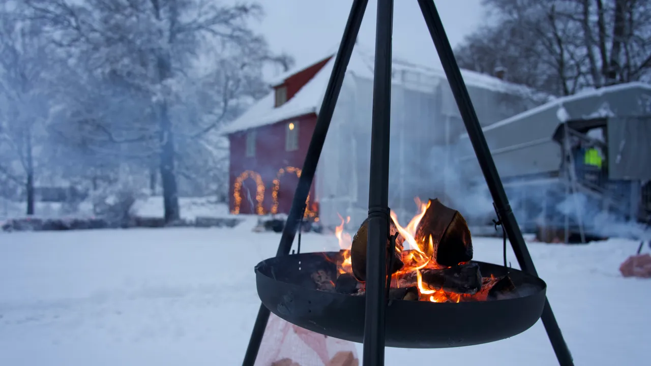 En bålplass midt i en snødekt hage.