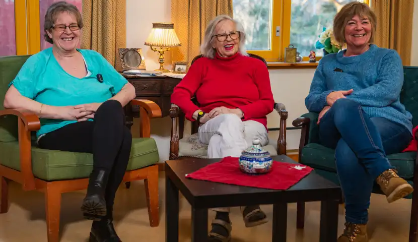 Søsken smilen sammen på eldrehjem.