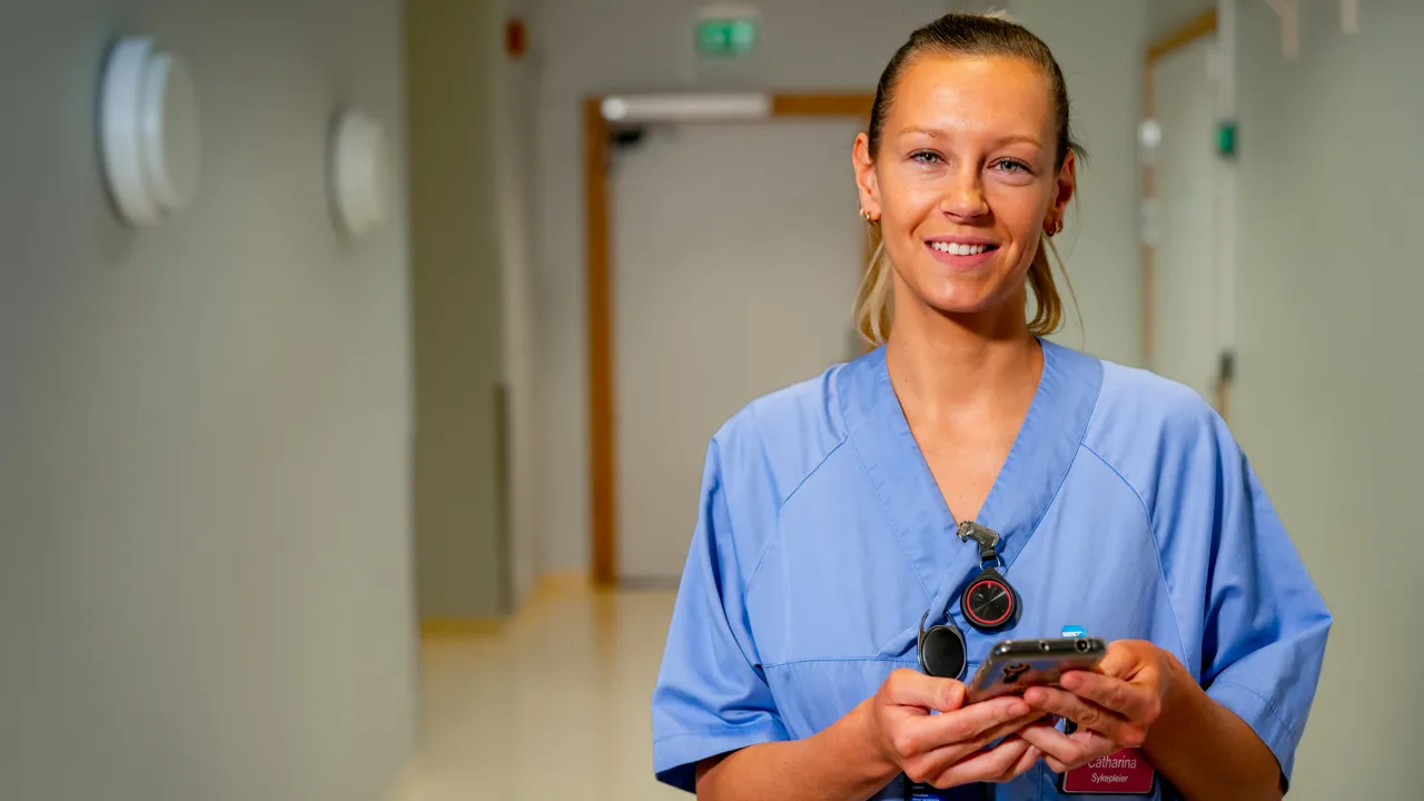 Sykepleier smiler til kamera.