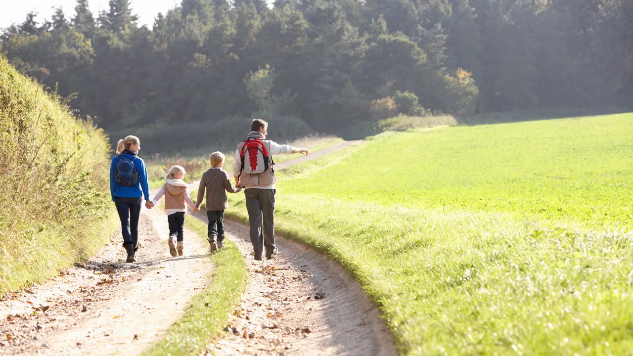 En gruppe mennesker som går langs en grusvei.