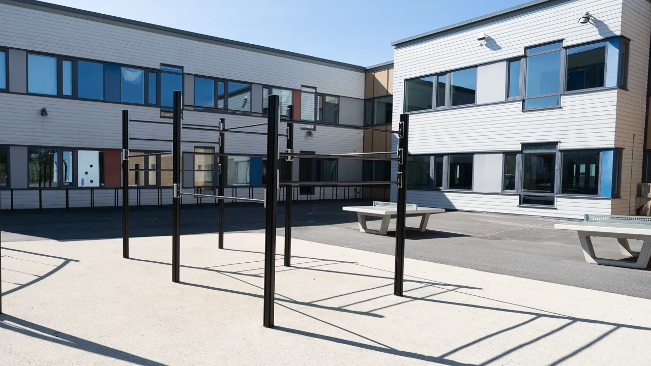 En gruppe metallstolper som står foran en bygning.
