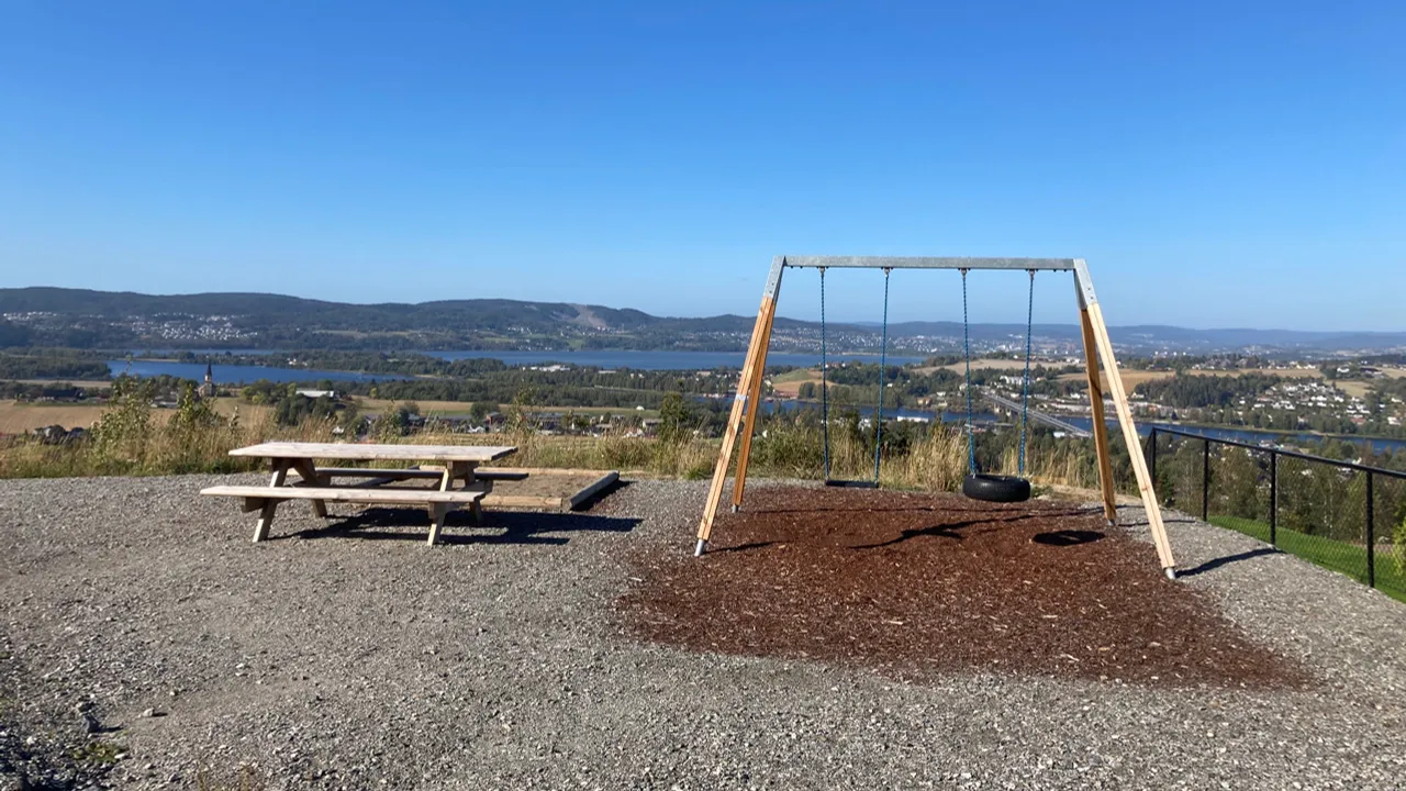 Et huskesett av tre som står på toppen av en grusbane.