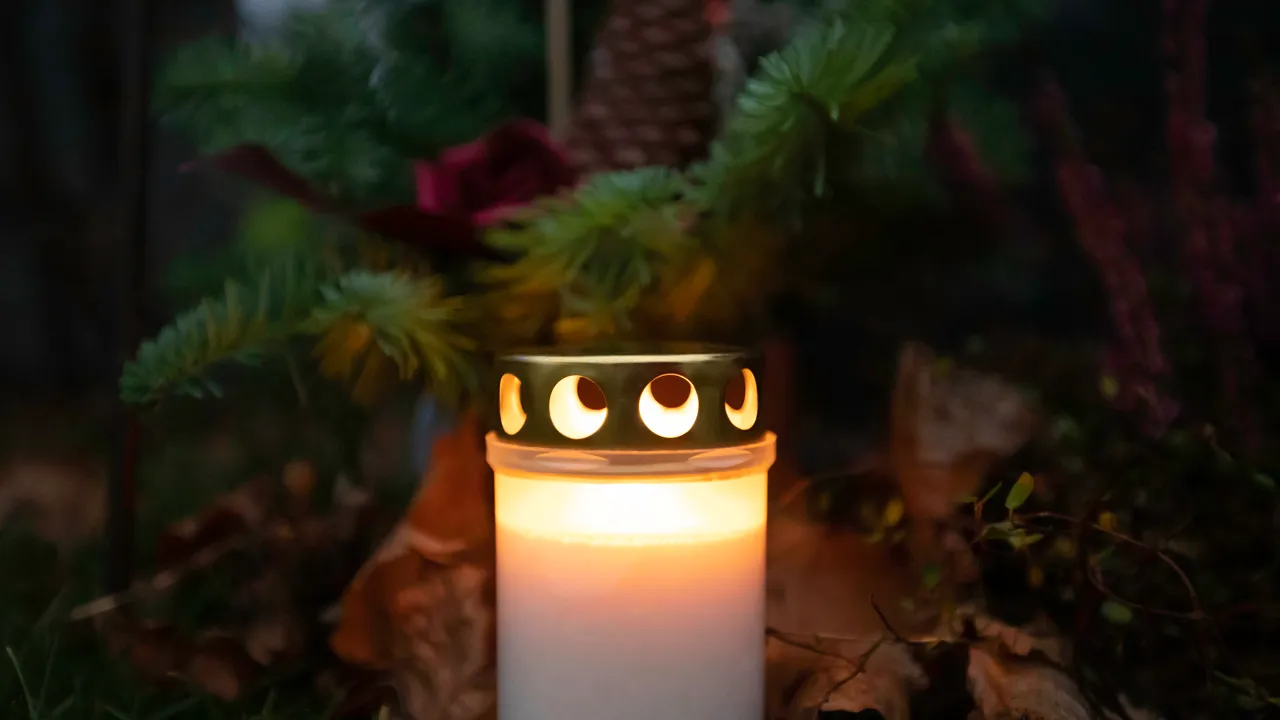 Et gravlys som er tent på en kirkegård