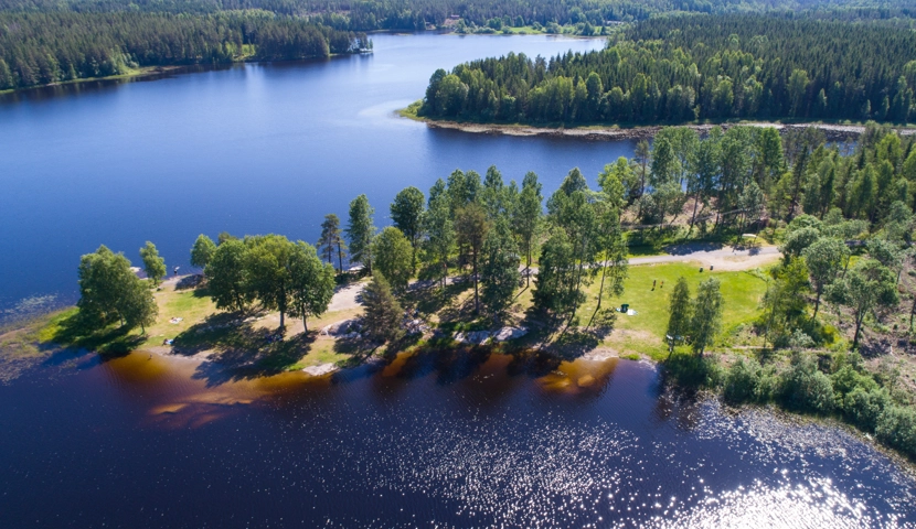 Et luftfoto av en innsjø omgitt av trær.