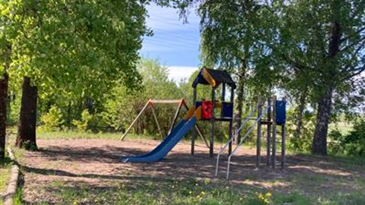 En lekeplass i skogen med en sklie.