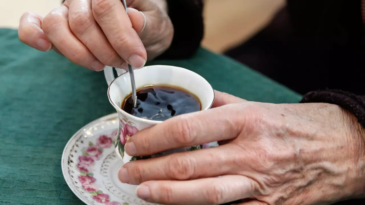 Kvinne rører i kaffekopp