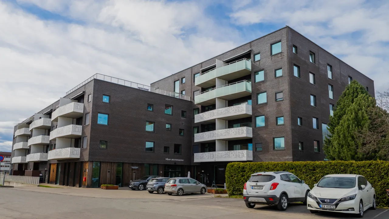 To murbygninger med balkonger, en med tre etasjer og en med fem etasjer.