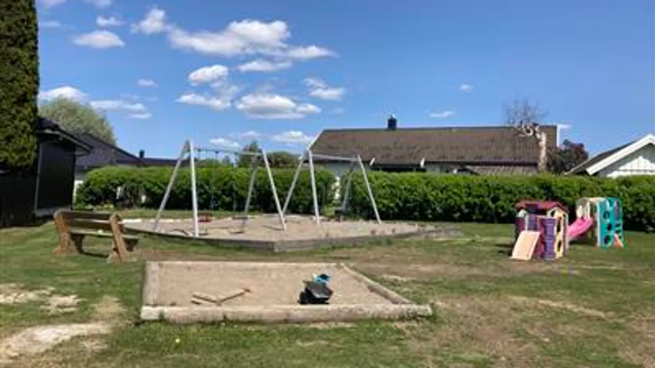 En lekeplass i en park med et huskesett.