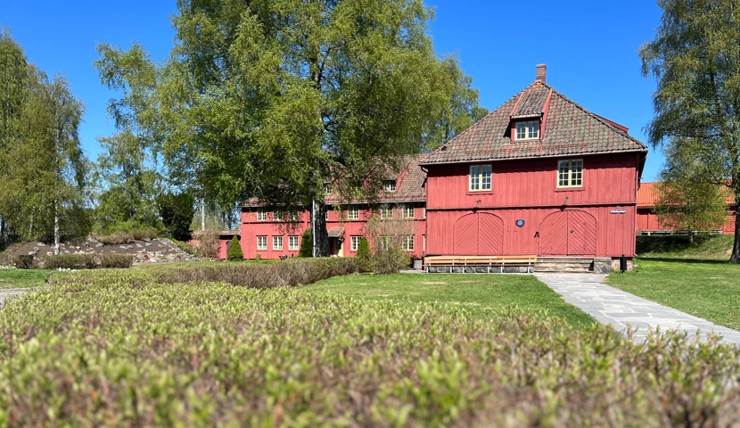 En stor rød låve som ligger ved siden av en frodig grønn eng.