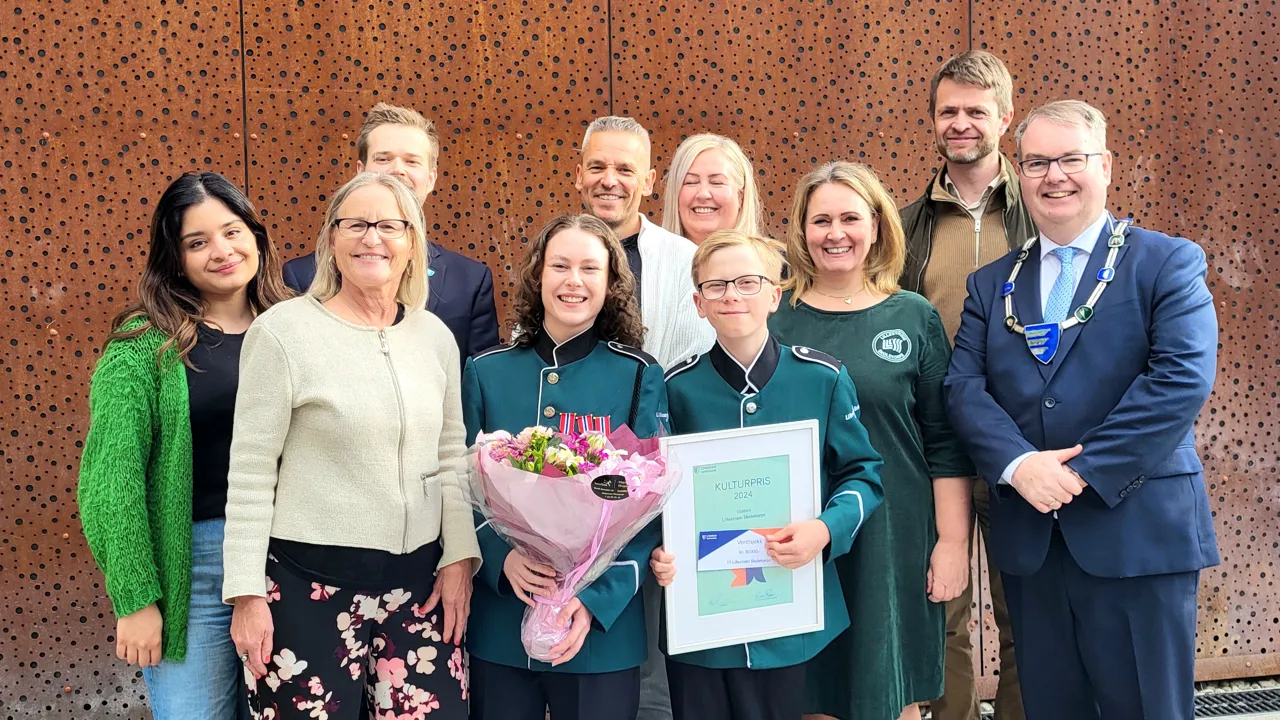 Gruppe med smilende mennesker som består av medlemmer av Lillestrøm skolekorps, ordfører og kulturansatte i Lillestrøm kommune.