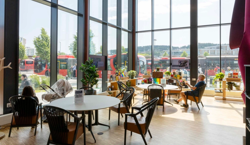 Et stort rom med mange bord og stoler.