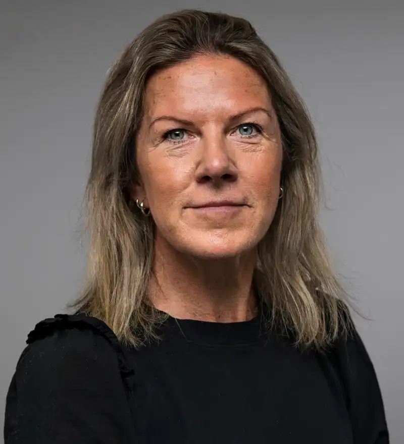 En kvinne i svart skjorte poserer for et bilde.
