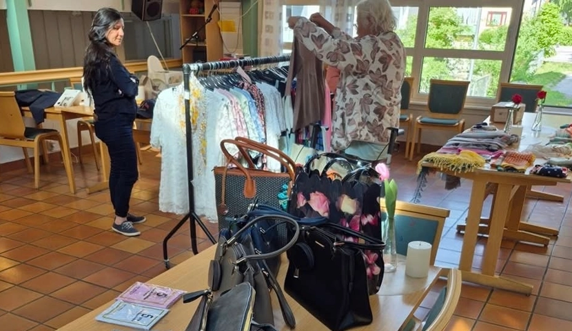 En kvinne som står i en butikk og ser på klær.