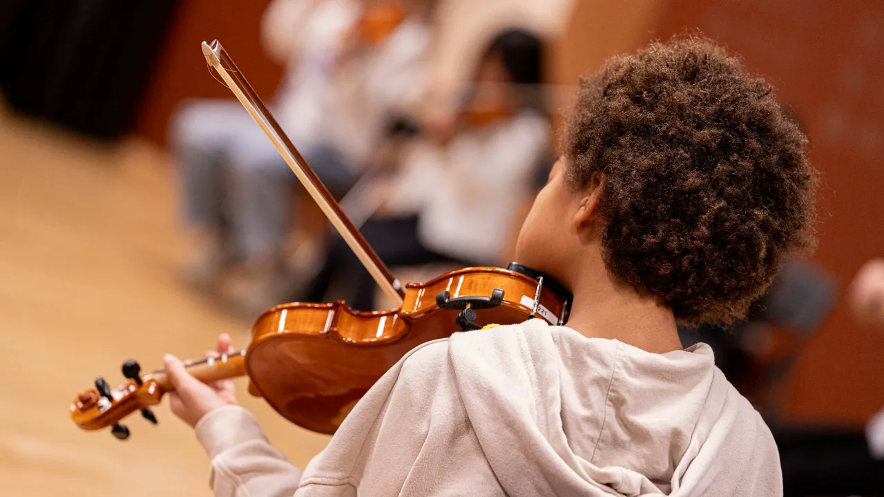En ung gutt som spiller fiolin