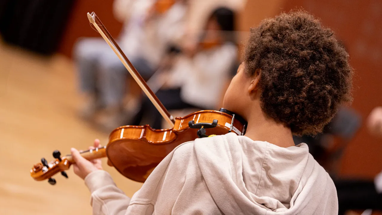 En ung gutt som spiller fiolin