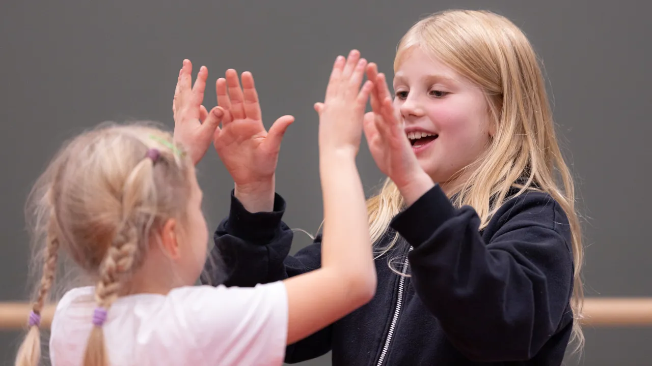 To unge jenter leker med hendene sine.