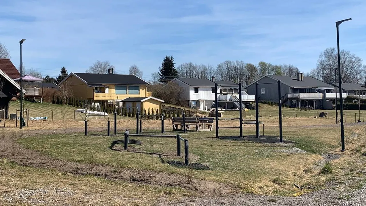 En park med mange hus i bakgrunnen.