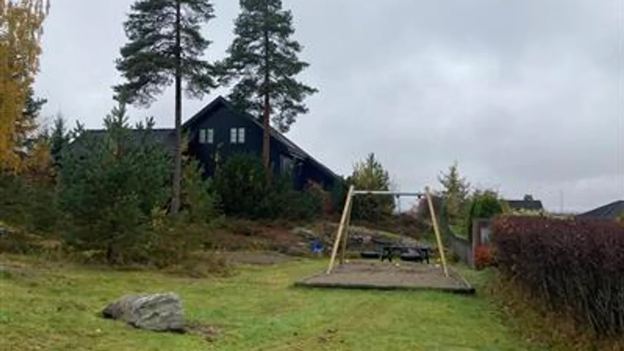 En huskestativ i en hage med et hus i bakgrunnen.