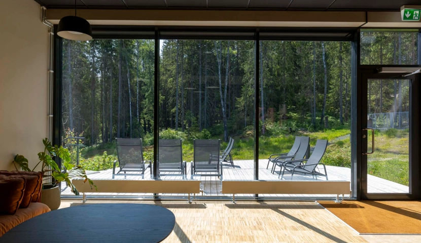 En stue fylt med møbler og store vinduer.