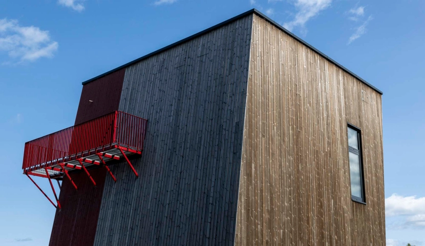 En høy trebygning med en rød balkong.