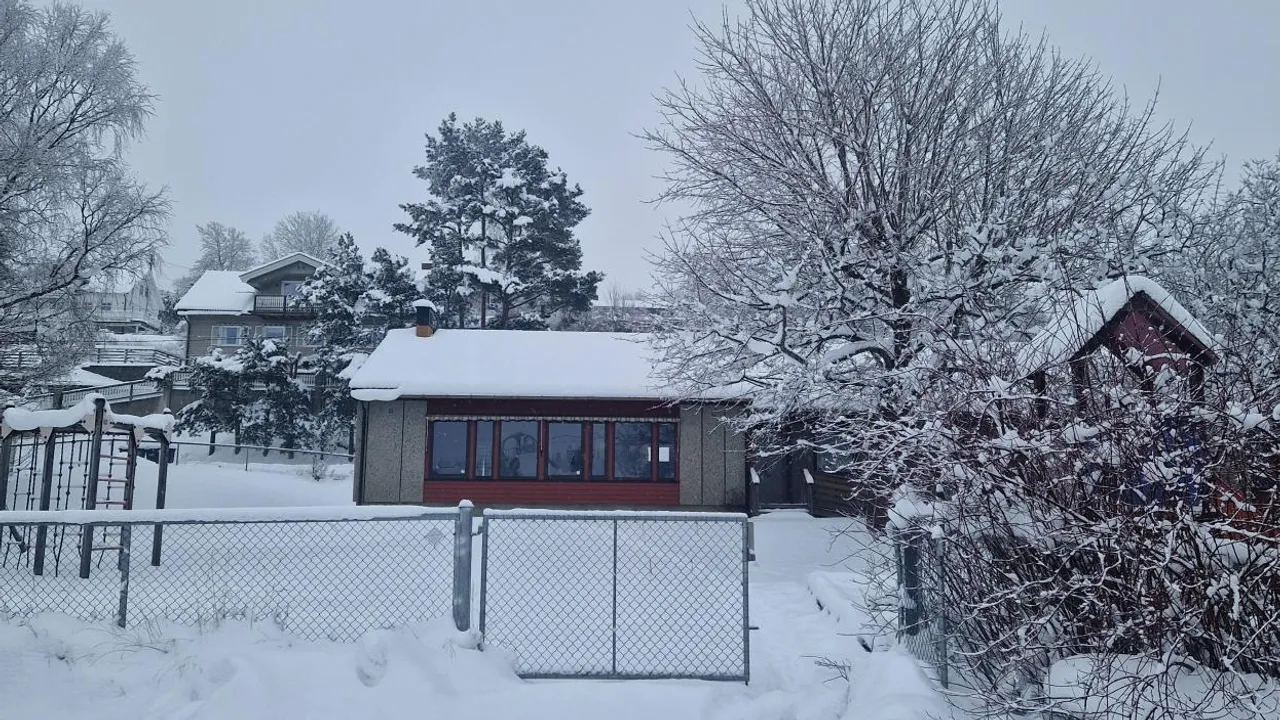 En rød bygning på en etasje innenfor et gjerde.