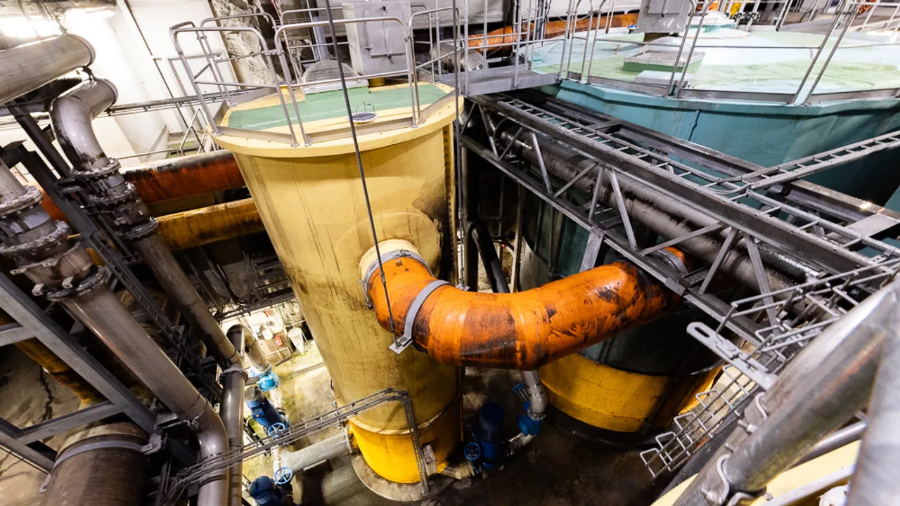 Et stort gult rør ved siden av en stor gul tank.