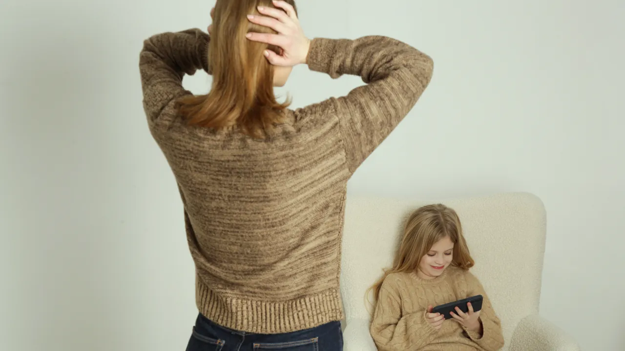 En kvinne kjefter på en liten jente.