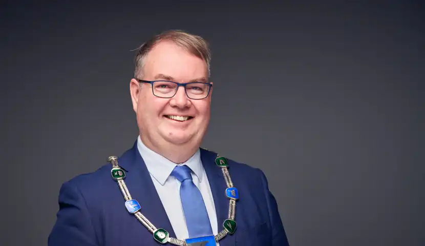 En mann i bl&aring; dress og bl&aring;tt slips.