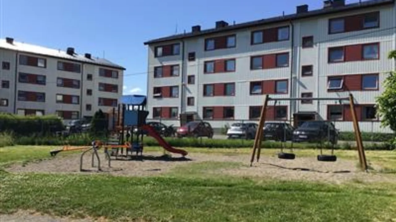 En lekeplass foran en boligblokk.