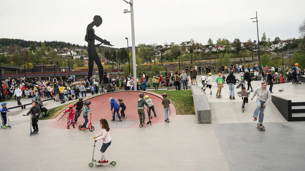 En gruppe mennesker som kjører sparkesykkel i en skatepark.