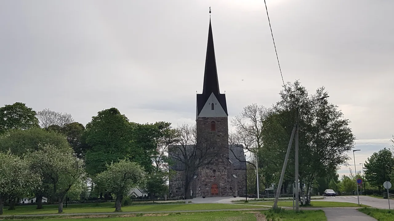 En kirke med et kirketårn på en overskyet dag.
