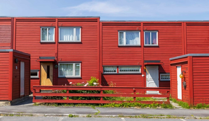 En rekke røde hus på et gatehjørne.