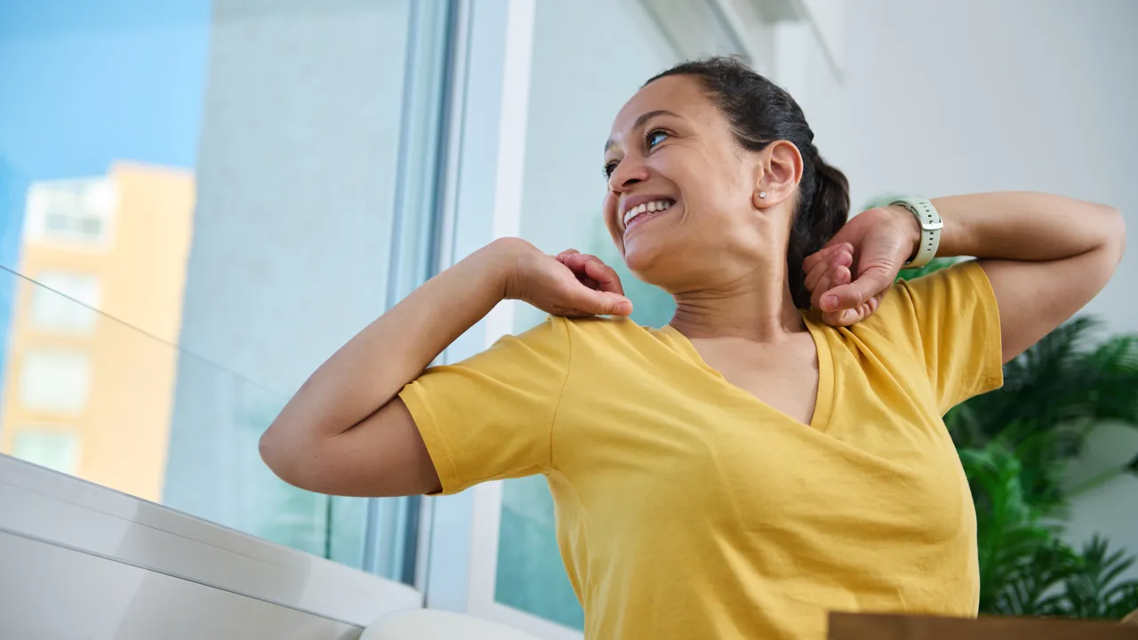 En kvinne strekker seg og ser ut av vinduet