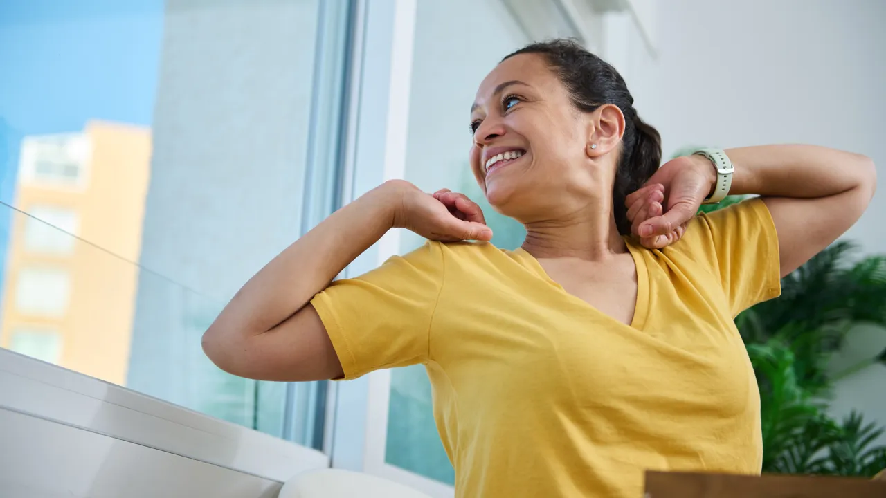 En kvinne strekker seg og ser ut av vinduet