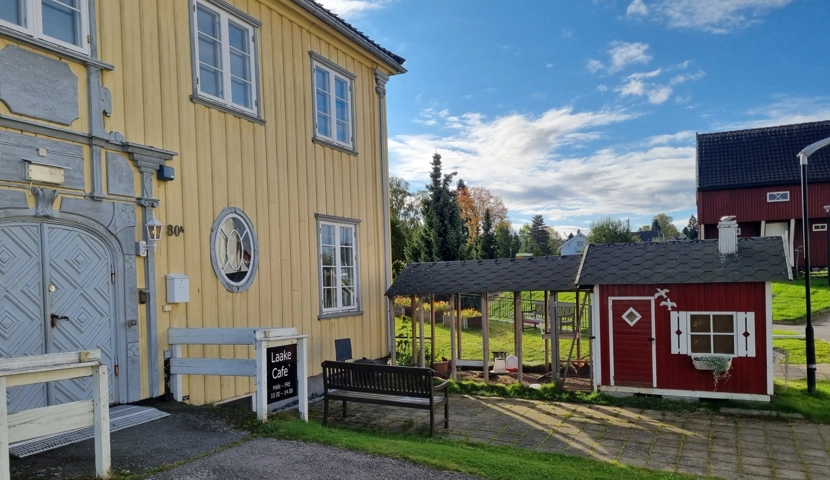 En gul bygning med en hvit benk foran.