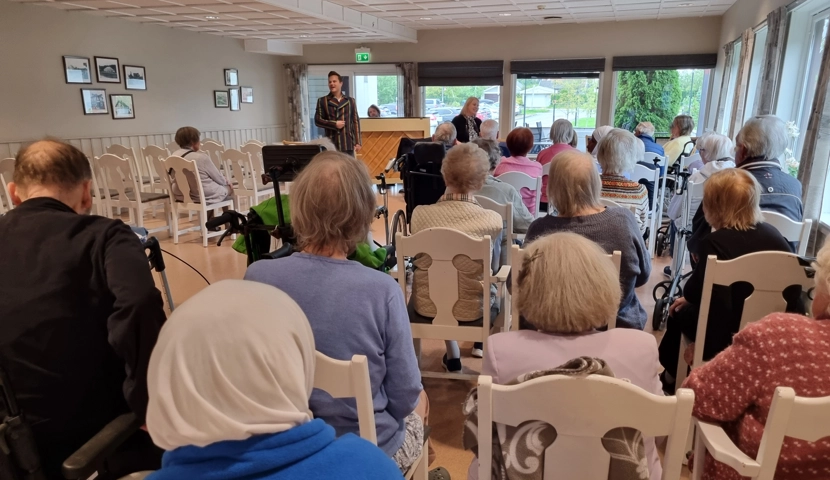 En gruppe mennesker som hører på konsert.