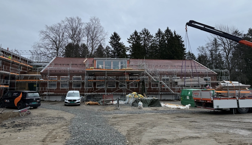 En byggeplass med en kran og en bygning under oppføring.