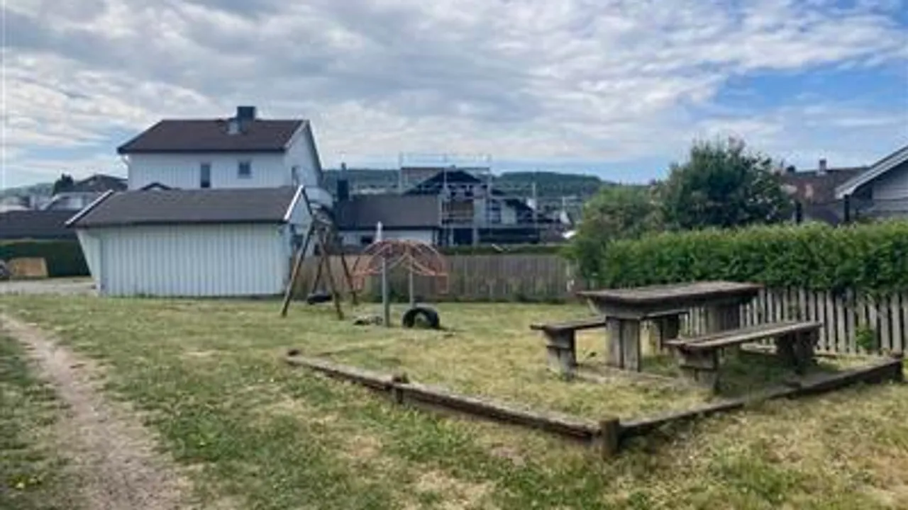 En uteplass med huskestativ og piknikbord.