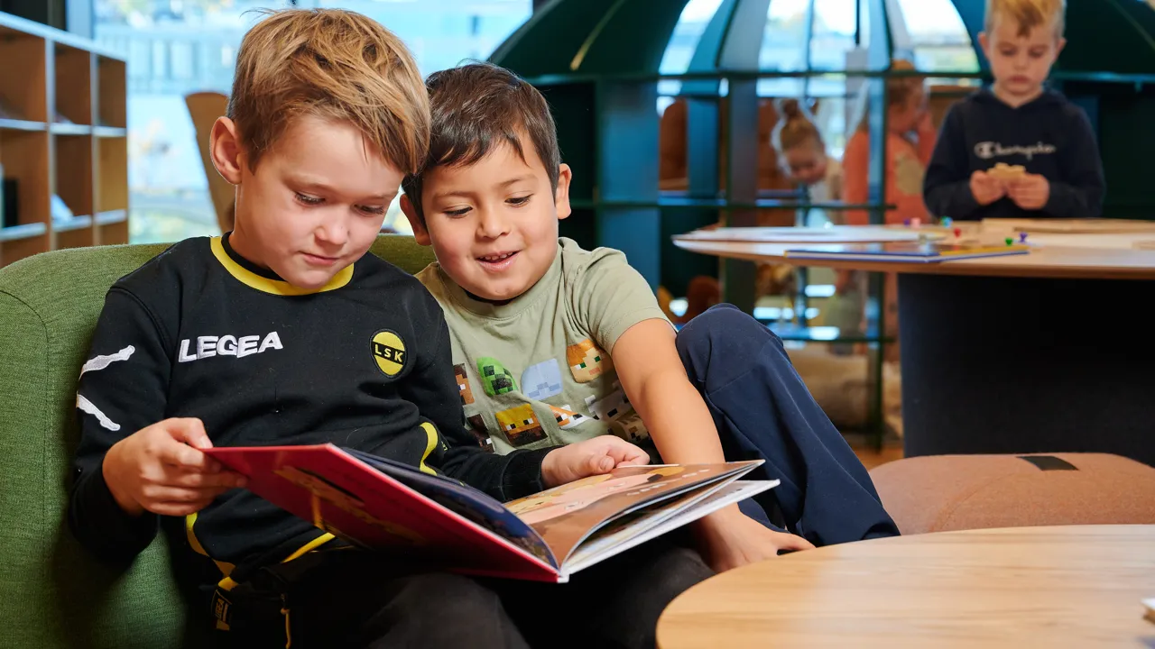 Gutter som leser på biblioteket